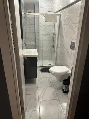 a white bathroom with a toilet and a sink at Besiktas Guest House in Istanbul
