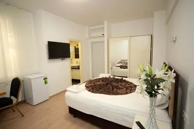 a bedroom with a large bed with a vase of flowers at Beyaz Köşk Hotel in Istanbul