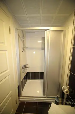 a bathroom with a shower and a white tub at Beyaz Köşk Hotel in Istanbul