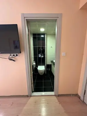 a bathroom with a toilet and a tv on a wall at Beyaz Köşk Hotel in Istanbul