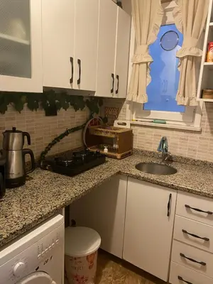 a kitchen with white cabinets and a sink and a window at sultans corner in Istanbul