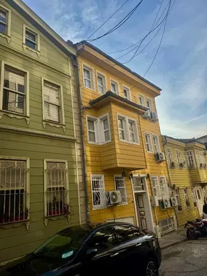 a yellow and green building with a car parked in front at Grand Süleymaniye Hotel in Istanbul