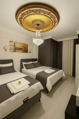 a hotel room with two beds and a chandelier at Grand Süleymaniye Hotel in Istanbul