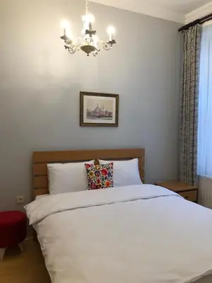 a bedroom with a white bed and a chandelier at Ozcans Pera Flats 3 in Istanbul