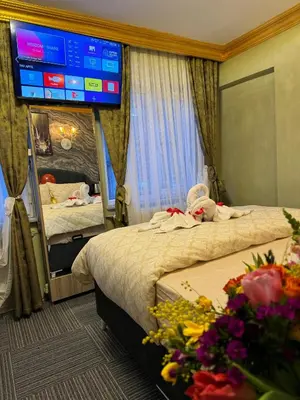 a hotel room with two beds and a large tv at Gür Star Hotel in Istanbul