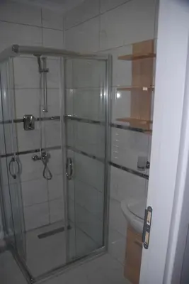 a shower with a glass door in a bathroom at Ozcans Pera Flats 8 in Istanbul