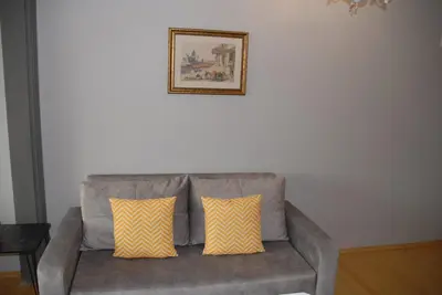 a gray couch with two yellow pillows in a living room at Ozcans Pera Flats 8 in Istanbul
