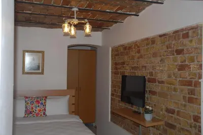 a bedroom with a brick wall and a bed and a television at Ozcans Pera Flats 10 in Istanbul