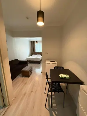a living room with a table and chairs and a bed at Şişli Suites - Room26 in Istanbul
