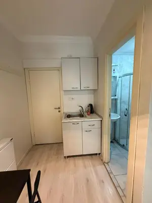 a small kitchen with white cabinets and a sink at Şişli Suites - Room26 in Istanbul