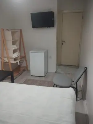 a room with a bed and a chair and a television at Şişli Suites - Room47 in Istanbul