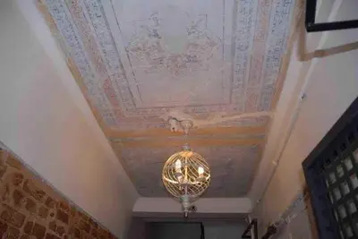 a chandelier hanging from a ceiling with a painted ceiling at Ozcans Pera Sururi Flats 4 in Istanbul