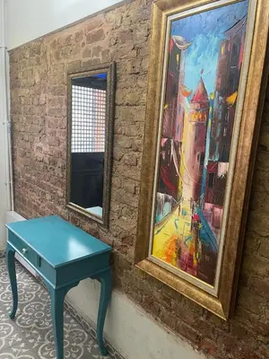a blue table next to a painting on a brick wall at Ozcans Pera Sururi Flats 4 in Istanbul