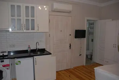 a kitchen with white cabinets and a sink and a door at Ozcans Pera Sururi Flats 4 in Istanbul