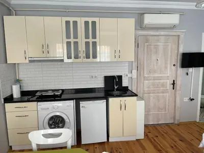 a kitchen with white cabinets and a washing machine at Ozcans Sururi Pera Flats 8 in Istanbul