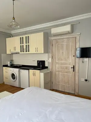 a kitchen with white cabinets and a white bed at Ozcans Sururi Pera Flats 8 in Istanbul