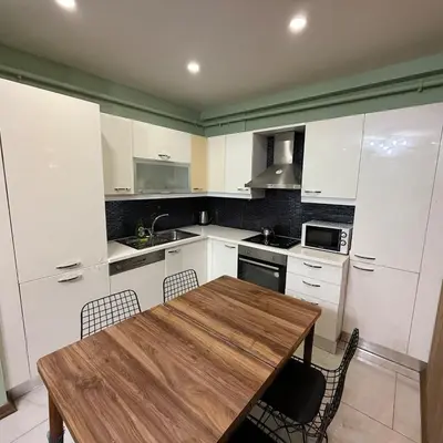 a kitchen with a wooden table and white cabinets at Bright 2BR Home in Central Istanbul in Istanbul