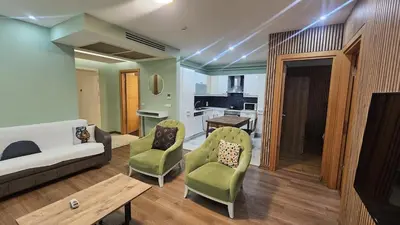a living room with a couch and chairs and a kitchen at Bright 2BR Home in Central Istanbul in Istanbul