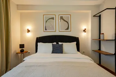 a bed with a black headboard in a bedroom at 3-Bedroom 2-Bathroom Duplex Apartment with Elevator in Istanbul
