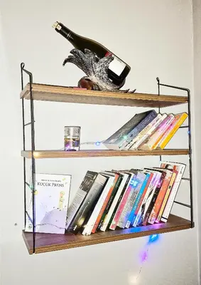 a book shelf with a bottle of wine and books at Sweet Home Kadikoy in Istanbul