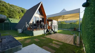 a small house with a large tent in a yard at Hilltop Bungalov Sapanca 3 in Sapanca