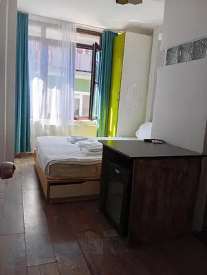 a bedroom with a bed and a desk and a window at As Pansiyon in Istanbul