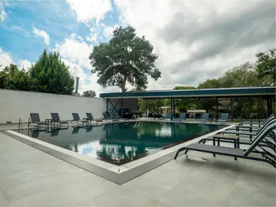a large swimming pool with chairs and a building at Verona Ağva in Sile