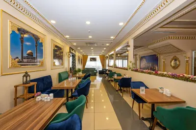 a restaurant with wooden tables and green chairs at Harmony Hotel Merter & SPA in Istanbul