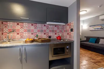a kitchen with a sink and a living room at Lampa Design Hotel-Special Category in Istanbul