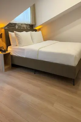 a bedroom with a large bed with white sheets at Positive Hotel in Arnavutköy