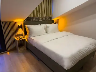 a bedroom with a large bed with white sheets at Positive Hotel in Arnavutköy