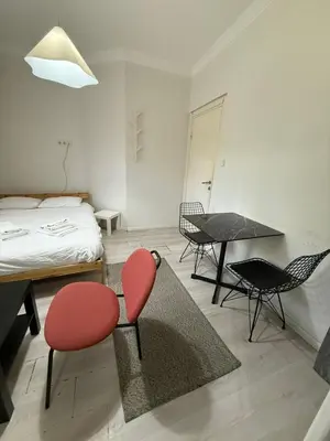 a bedroom with two red chairs and a table and a bed at Şişli Suites - Room21 in Istanbul