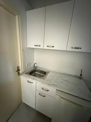a kitchen with a sink and white cabinets at Şişli Suites - Room21 in Istanbul