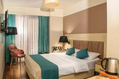a hotel room with a bed and a chair at Hotel Bossuite Kadikoy in Istanbul