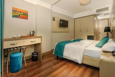 a hotel room with a large bed and a desk at Hotel Bossuite Kadikoy in Istanbul