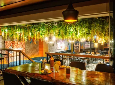 a dining room with a wooden table and plants on the wall at Hotel Bossuite Kadikoy in Istanbul