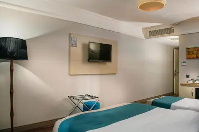 a hotel room with a bed and a tv on the wall at Hotel Bossuite Kadikoy in Istanbul