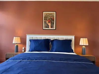a bedroom with a bed with blue sheets and two lamps at Bosphorus Villa Arnavutköy 5BR for 12 Guests in Istanbul