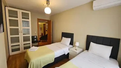 a hotel room with two beds and a hallway at Taksim'de 2 yatak odalı daire, güvenlik, havuz, spa, otopark in Istanbul