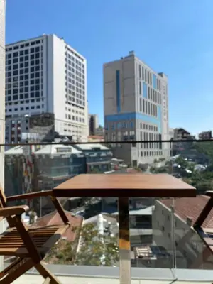 a table and chairs on a balcony with a view of a city at Taksim'de 2 yatak odalı daire, güvenlik, havuz, spa, otopark in Istanbul