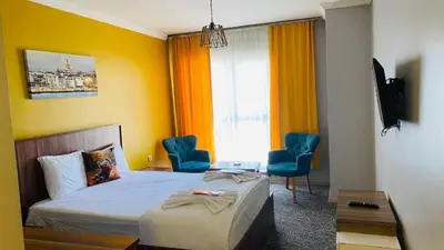 a hotel room with a bed and chairs and a window at Ay suit in Esenyurt
