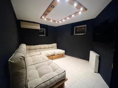 a living room with a couch and a ceiling with lights at Wooden Villa in Istanbul