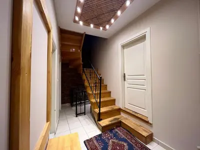 a hallway with a white door and stairs with a rug at Wooden Villa in Istanbul