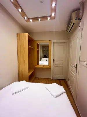a bedroom with a white bed and a small room at Wooden Villa in Istanbul