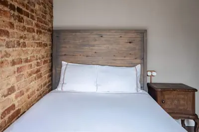 a bedroom with a white bed with a brick wall at Grand Historic 3BD2Bath Galata Tower Pad! #408 in Istanbul