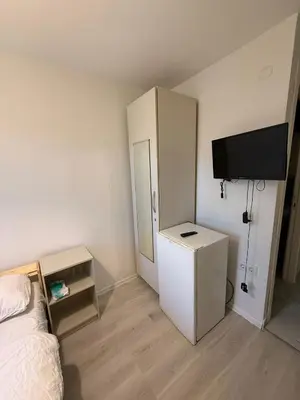 a bedroom with a bed and a tv and a cabinet at Şişli Suites - Room44 in Istanbul