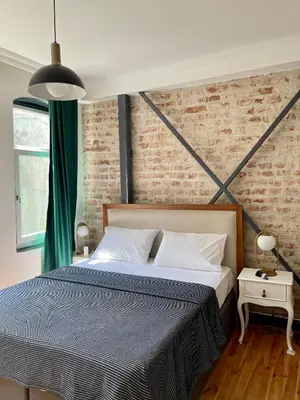 a bedroom with a bed and a brick wall at Balat Homes & Apartments Nick in Istanbul