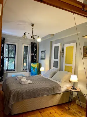 a bedroom with a large bed and two windows at Balat Homes & Apartments Cottage in Istanbul