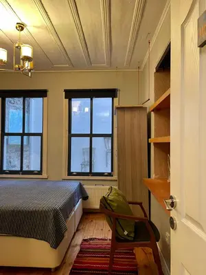 a bedroom with a bed and two windows at Balat Homes & Apartments Cottage in Istanbul