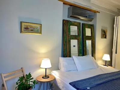 a bedroom with a bed and two lamps and a mirror at Balat Homes & Apartments Cottage in Istanbul